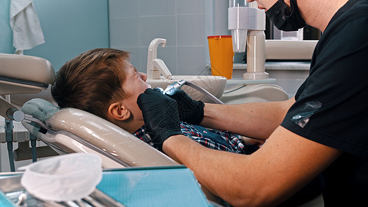 一个小男孩在现代牙医里 修补牙齒图片