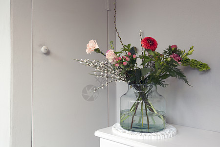 玻璃花瓶中美丽的春花 靠近时尚住宅的灰色墙壁 现代室内装饰和复制空间图片