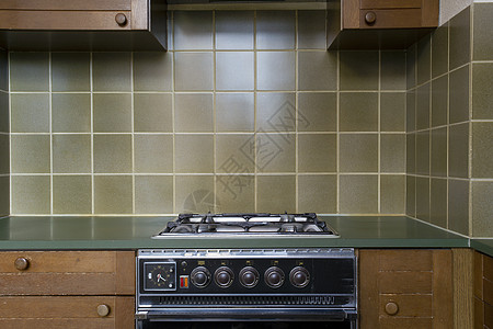 一个古老的旧厨房 里面有古董烤炉 棕色木制柜子 绿色陈年旧式瓷砖 需要翻修图片