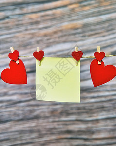 红心挂在木头背景 情人日 妇女日母亲日概念 复制空间的红色纸条粘贴笔图片