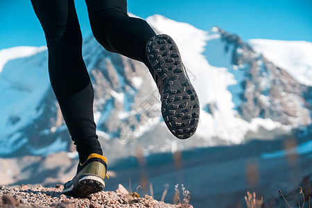 人正在山上奔跑 双腿紧紧慢跑者内衣运动鞋训练气候石头男人赛跑者运动冰川图片