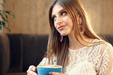 在咖啡店喝咖啡的漂亮年轻女人 享受咖啡早餐闲暇餐厅香气巧克力杯子成人女性黑发味道图片