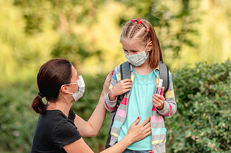 母亲放学前给女儿戴面罩学校小学生面具消毒剂晴天背包孩子教育医疗童年图片
