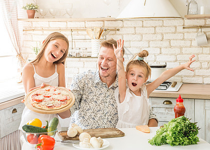 有女儿准备比萨饼的爸爸食物微笑面包食谱厨师父母男性美食家庭面粉图片