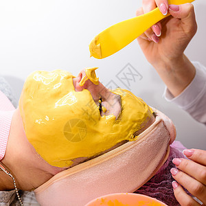 女人脸上的金面罩 放松和皮肤液化用的芳香面罩 参观温泉疗养所中心女性金叶子美容身体女士治疗口罩按摩面膜图片