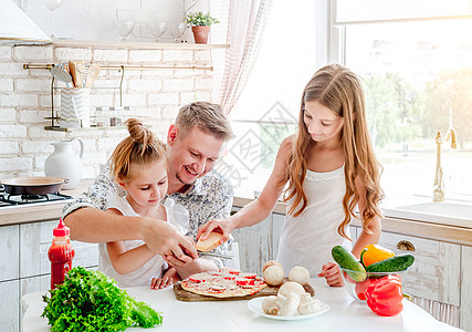 有女儿准备比萨饼的爸爸厨房食物女孩们女性烹饪厨师美食乐趣孩子食谱图片