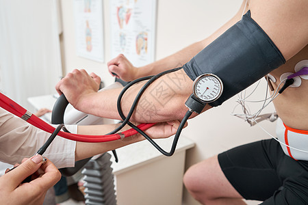 护士测量动脉张力 男病人踩着自行车测力计压力测试系统检查心脏功能 运动员在医学研究中进行心脏压力测试卫生医生技术职业监控攻击专家图片