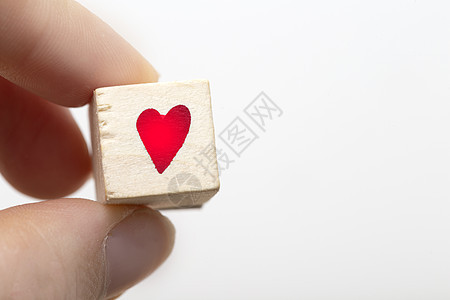 手握着红色心脏符号的木制立方体 在白色背景上被孤立图片
