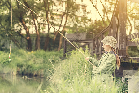 拿着棍子的小鱼女乐趣童年森林女孩闲暇假期池塘浮标渔夫钓鱼图片