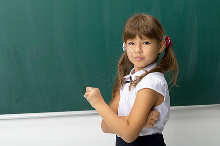 漂亮女孩在黑板上摆姿势粉笔孩子女性女学生木板小学生衬衫瞳孔课堂学校图片