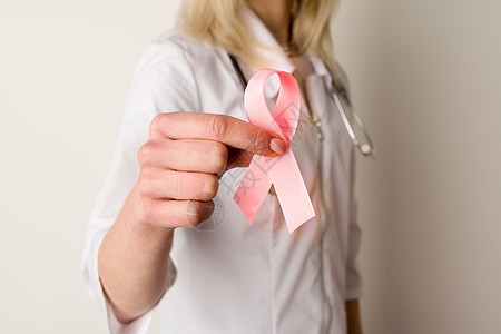 手握粉色丝带的女医生胸部病人木头丝带考试活动照片预防志愿者治疗图片