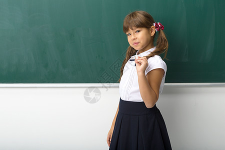 漂亮女孩在黑板上摆姿势学校小学生知识青年瞳孔教育班级粉笔衬衫孩子图片