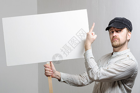 青年工人用手指在空白的横幅上海报手势木板推介会年轻人工作室广告广告牌微笑成人图片