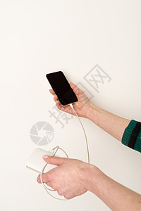 手握和使用智能手机 同时向电力银行充电图片