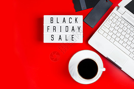 黑色星期五销售概念 红色背景的笔记本电脑和咖啡杯 广告名牌图片