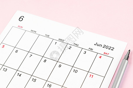 2022年6月的日历表 上面有粉红色背景上的笔图片