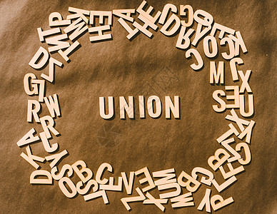 木立方体字母表字母中的联合词在质朴的纸张背景上的顶部视图乡村积木英语大写字母插图风格国家办公室政治材料图片