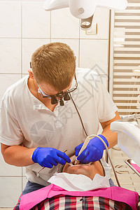诊所的牙医 tartar移除程序 望远镜中的牙医清除了病人嘴部的沥青油图片