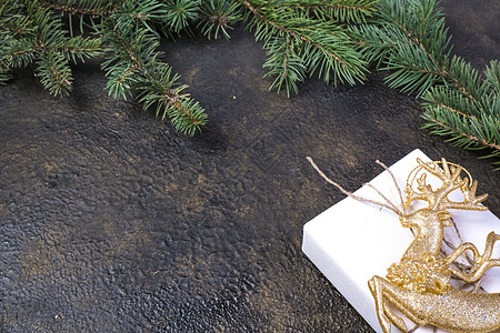冷杉树枝 金丝带 黑色牛皮纸礼品盒的圣诞组合 带有金色浮雕背景和文字位置庆典海报绳索辉光云杉花环玩具展示金子卡片图片
