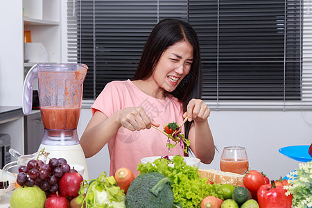 在厨房吃沙拉的不开心女人午餐重量杯子女孩桌子烹饪女士食物女性蔬菜图片