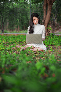 在公园使用笔记本电脑的美女女性女孩教育学生花园快乐日落微笑大学阳光图片