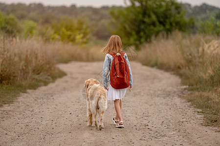 有金色猎犬的女孩闲暇幸福场地阳光学校童年背包自由朋友女性图片