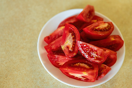 白色盘子上的新鲜切面番茄 白板桌上有西红柿片 有很多复制空间图片