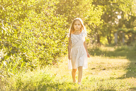 穿白裙子的小女孩看着边站着公园幼儿园闲暇快乐乐趣女孩舞蹈农村孩子草地图片