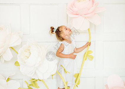 小女孩在演唱室装饰的对面工作室里摆着人造花朵裙子孩子乐趣头发艺术童年女性白色幸福魔法图片