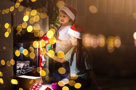 孩子们在庆祝圣诞节的温馨家庭里 在壁炉旁边开小礼物季节女孩房子朋友们展示场景兄弟孩子姐姐房间图片