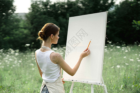妇女户外画画创作艺术风景的图片画架野餐女性黑发绘画工作森林艺术家学生画家图片