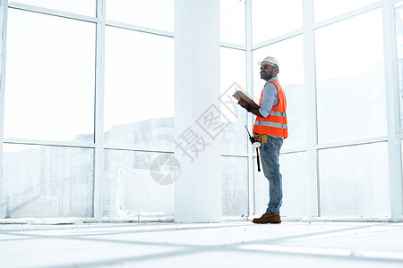 Foreman在施工工地工作 检查他在剪贴板上的笔记承包商安全男人建筑清单商业顾问报告力量工人图片