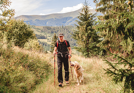 带着狗走在路上的爬山者远足旅游背包闲暇晴天活动远足者男人农村荒野图片