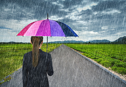 拥有雨伞 在乡村公路上下雨的女商务人士图片