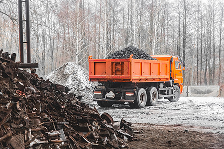 冬天 工业区或建筑工地的自卸车从车身上卸焦煤 旁边是一堆金属废料和垃圾矿石货运环境倾倒力量机械货车碎石运输卡车图片