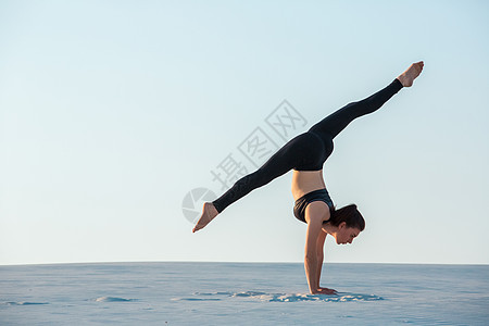 年轻女性练习反向平衡瑜伽 在沙滩上站立灵活性保健女士天空假期海岸线体操福利冒充卫生图片