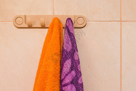 橙色和紫毛巾挂在衣架上 厕所有钩子图片
