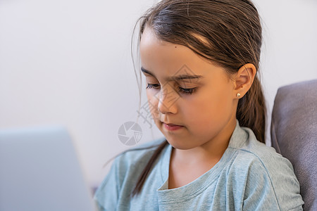 小女孩使用数字笔记本电脑电子学习概念 小女孩使用笔记本电脑 通过在线电子学习系统学习图片