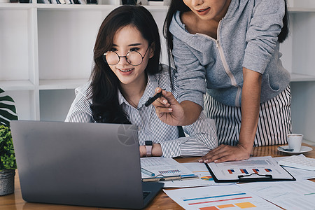 用于投资决策的数字平板电脑软件的两位女商务人士数据分析技术背景图片