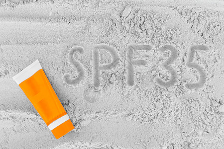 沙滩沙砂上的太阳保护因素的符号和标志 加上防晒霜 Spf 35概念图片