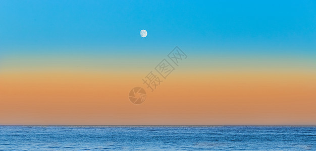 傍晚在海边的黄昏 天线上橙色日落 月亮下蓝天空图片
