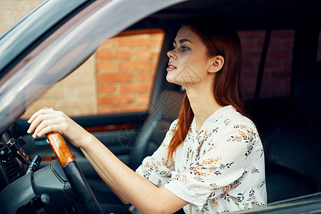 驾驶汽车生活方式旅行的可爱红发美女车轮车辆女孩眼镜奢华司机交通窗户头发魅力图片