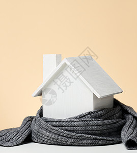 白色木制小型房屋 用灰丝绒围巾包着 建筑绝缘概念 维修贷款图片