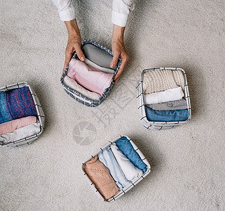 在现代存储系统的帮助下 一位整洁的家庭主妇在进行一般清洁时将物品放入洗衣容器中 顶视图 一个美丽舒适的组织的概念毛巾衣服房子案例图片