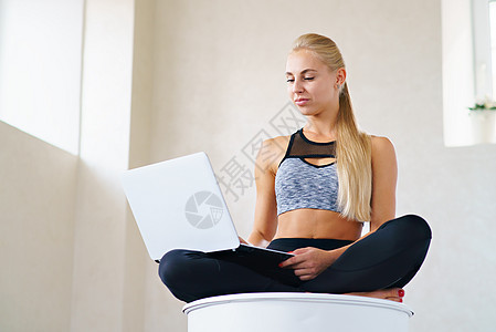 带笔记本电脑的露珠运动女运动员平衡练习沉思头发有氧运动女性瑜伽身体体操电话图片