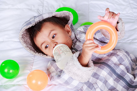 婴儿和婴儿在床上喝瓶装牛奶食物乐趣孩子喜悦戒指出牙期夹克塑料饮料瓶子图片