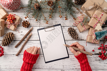 顶视图手在一张白纸上写下新年目标决议或购物清单 模拟设计挑战日记笔记本商业白色工作战略动机小样咖啡图片