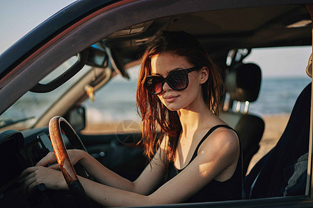 戴着太阳眼镜的开心女人 驾车出行旅行镜子交通眼镜太阳商业车轮车辆司机女孩魅力图片