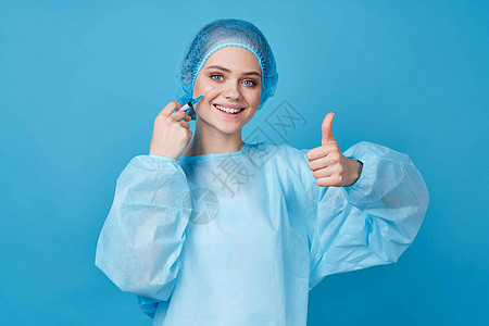 医生穿着防护服治疗医院蓝色背景工作金发注射器保健实验室药品生活工作室手套女性图片