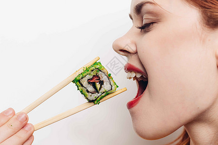 开心的红头发女人 筷子寿司日本菜女性摄影美丽舌头服务海鲜主食工作室黄瓜正方形图片
